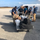 Relief team stages supplies beside a jet for rapid transport