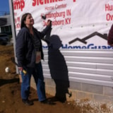 Volunteer trims housewrap on exterior at Owensboro Habitat build