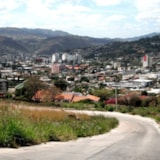 Honduran cityscape and hills along a winding hillside road