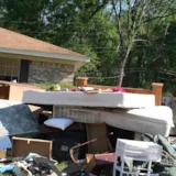 Flood-damaged belongings piled outside a Monroe, LA home