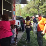 Volunteers serve meals to families at a Monroe relief site