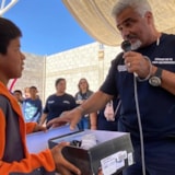 Volunteers present new shoes to a child in Juárez, Mexico