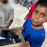 Children receive new shoes during aid outreach in Juárez, Mexico