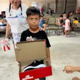 Child receives new shoes during aid outreach in Juárez, Mexico