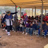 Children gather under a tent for humanitarian outreach in Juárez