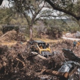 Relief teams clear flood debris along a Kerrville, TX riverbank