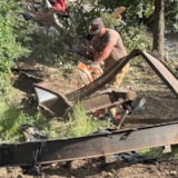 Volunteer cuts flood debris for safe removal in Kerrville, TX