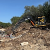 Relief team uses an excavator to clear Kerrville flood debris