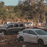 Flood damage in Kerrville: wrecked vehicles and a displaced home