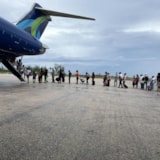 Evacuees board aircraft in the Bahamas after Hurricane Melissa