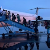 Evacuees board a plane after Hurricane Melissa in the Bahamas