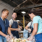 Volunteers assemble food kits inside a facility for relief