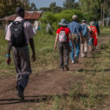 Missionary team walks a rural path toward village homes