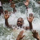 Baptism in a river with mission personnel and local believers