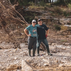 Volunteers survey damage from a flood-damaged riverbank in Kerrville