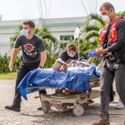 Medic Corps relief team transports a patient for treatment