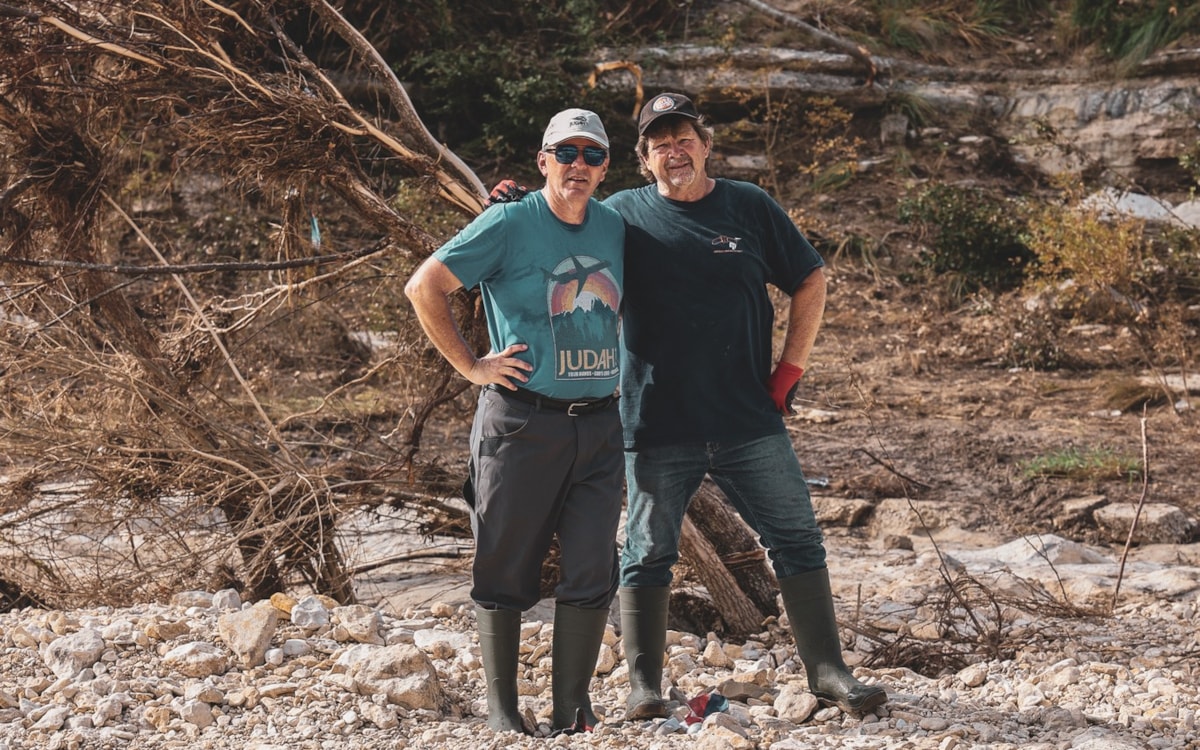 Volunteers survey damage from a flood-damaged riverbank in Kerrville