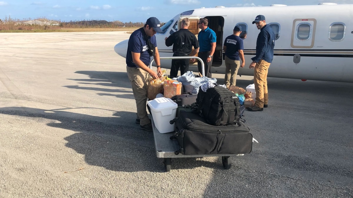 Relief team stages supplies beside a jet for rapid transport